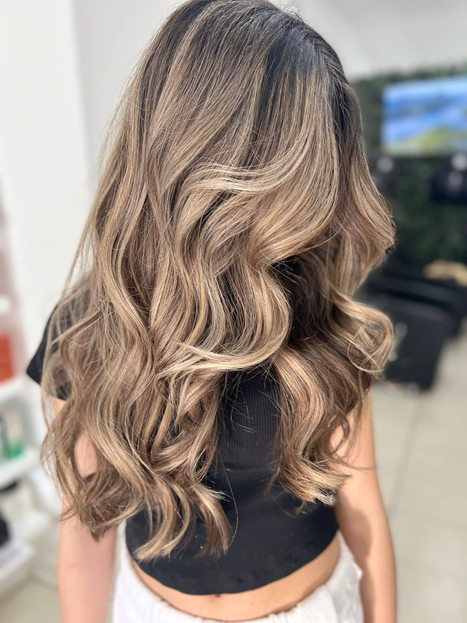 Brunette to bronde balayage with beige caramel ribbons on dark hair in Richmond Hill